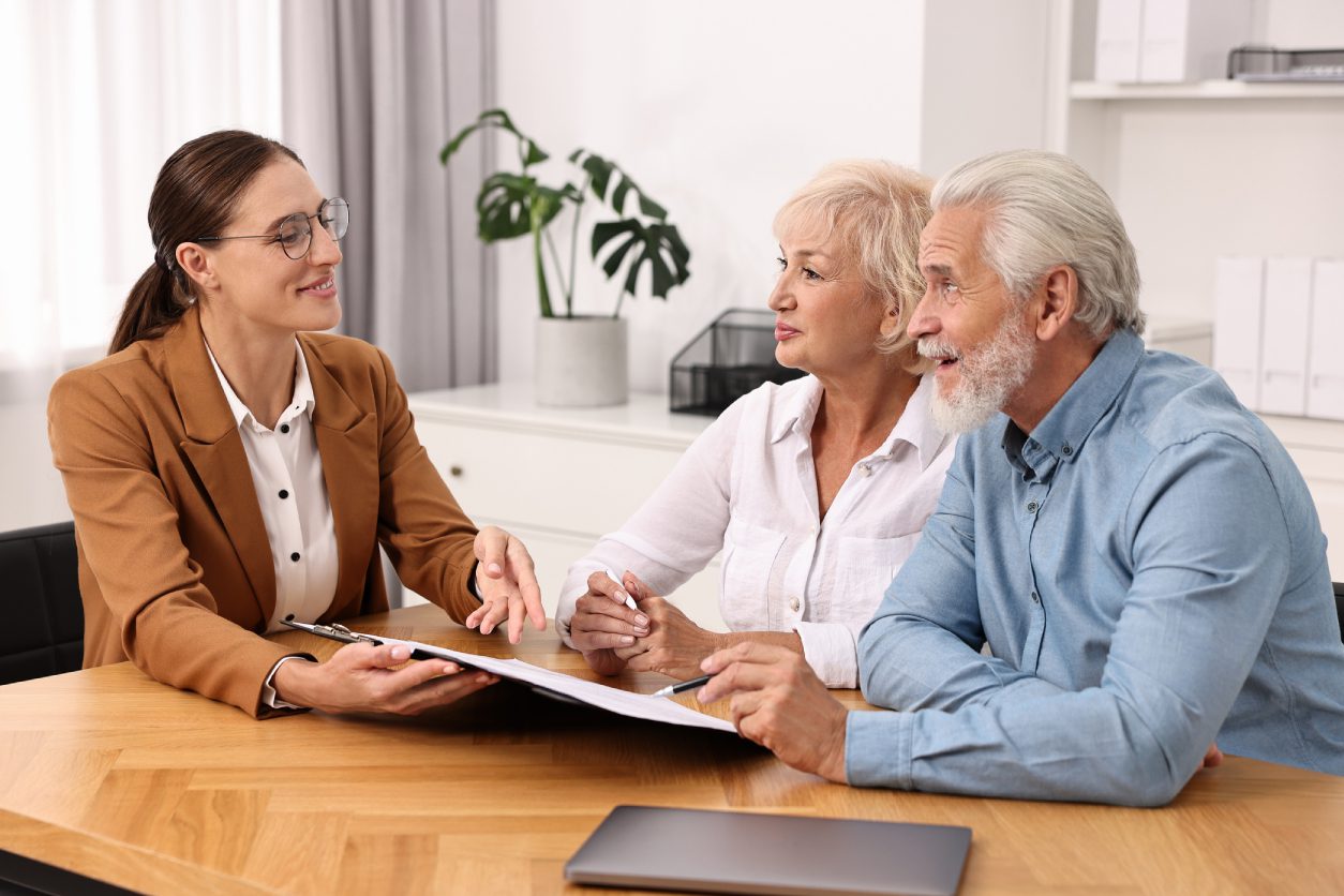 Advisor discussing paperwork with older couple.