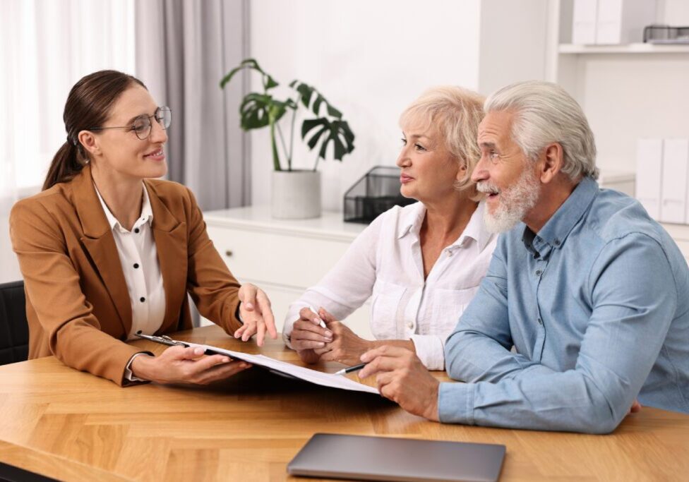 Advisor discussing paperwork with older couple.